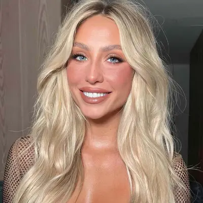 woman with bronzed skin and blonde hair smiling at camera