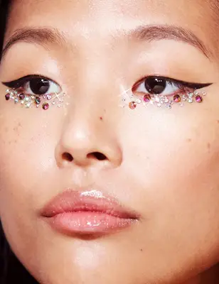 Close up of a woman with sparkly makeup under her eyes