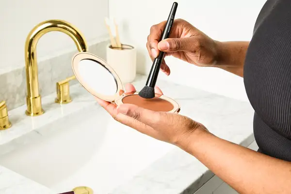 A person applies Charlotte Tilbury Airbrush Matte Bronzer