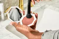 A person uses a makeup brush to apply Fenty Beauty Sun Stalk