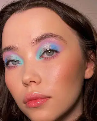 Close up of a halo eye makeup look in shades of turquoise, blue, silver, and purple