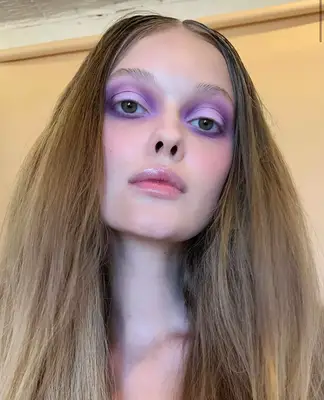 model is posing and wearing a matte lilac and purple eyeshadow look