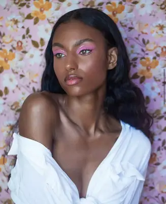 up close photo of a model wearing bright lilac matte eyeshadow with accents of glitter 