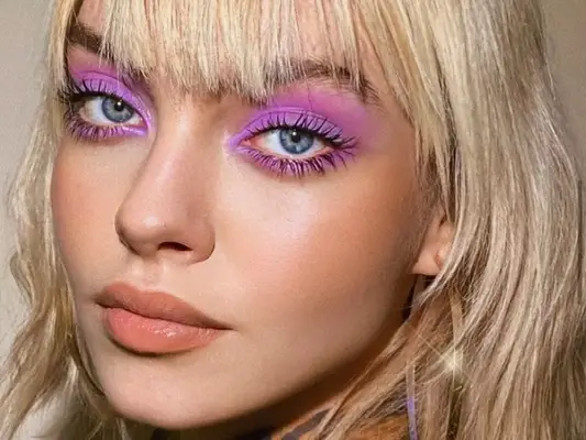 Close up of a lilac eyeshadow look on a model with blonde hair and bangs