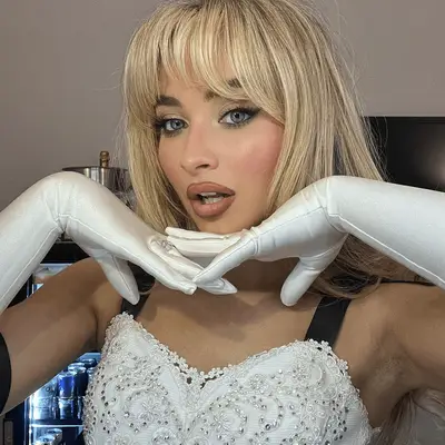 Sabrina Carpenter with a rosy cheek, nude gloss, and sparkly eyeshadow.