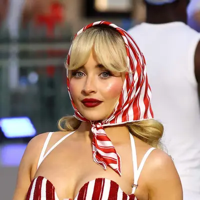 Sabrina Carpenter with a rosy cheek and dark red lip.