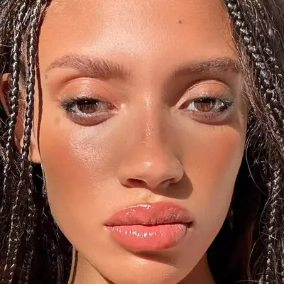 woman with feathered brows and sunkissed skin, with terracotta blush along the high points of her face