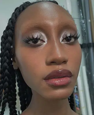 Close up of a model with silvery eyeshadow and cranberry, glossy lips