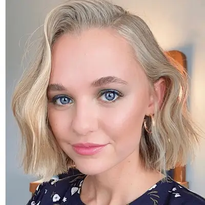 Short haired blonde model with taupe eyeshadow and dusty rose lipstick.