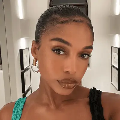 Lori Harvey wearing light brown eyeshadow and glossy, mocha colored lipstick.
