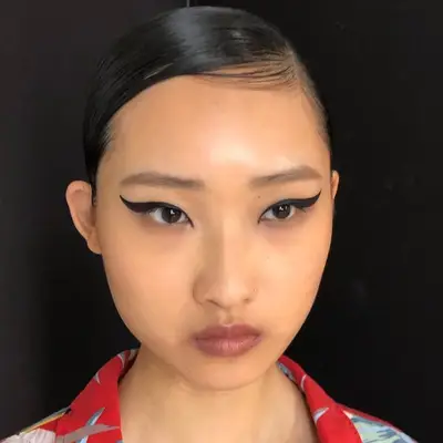 Model wears simple makeup look with 1920s-inspired winged liner