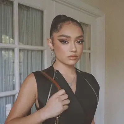 Avani Gregg wears double winged eyeliner and a high ponytail