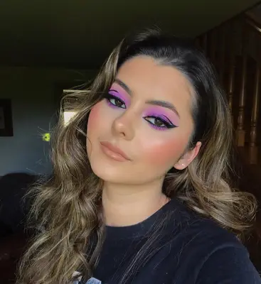 Woman wearing pink eyeshadow and double winged liner