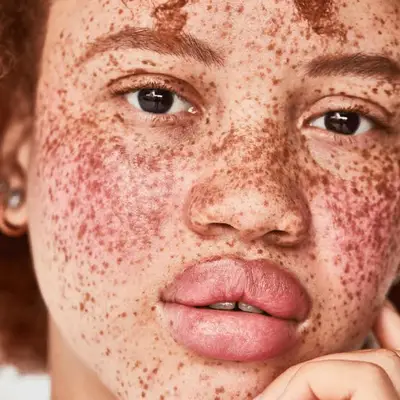 woman with freckles wearing pink monochrome makeup