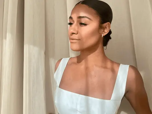 Ariana Debose with flawless skin looking out the window during the 2024 Paris Olympics