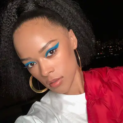 Serayah wears thick blue winged eyeliner and neutral lips
