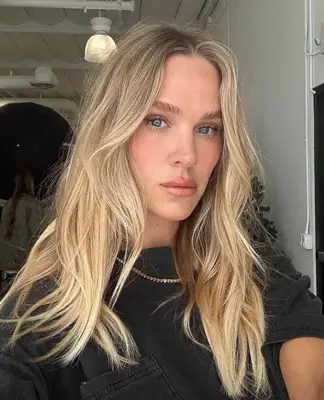 model wears natural makeup look that consists of light pink blush and lipgloss