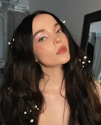 Dove Cameron wears an iridescent eyeshadow look and rosy colored lipgloss