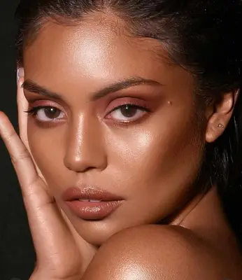 model wears sunkissed, bronze makeup look on eyes, cheeks and lips