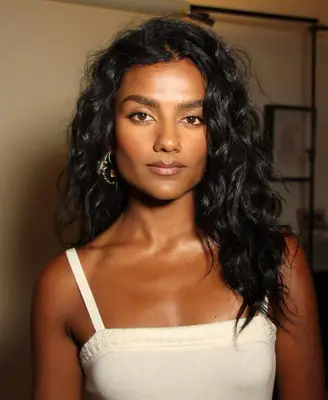 Simone Ashley wears a sculpted bronzed makeup look with minimal eyeliner and full brows