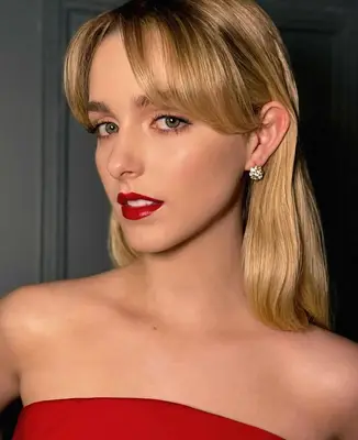 McKenna Grace wears thin black eyeliner on the eyes with a glowing complexion and bold satin red lips