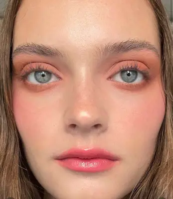 model wears peach monochromatic makeup look