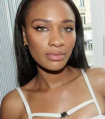 model wears winged eyeliner and baby pink lip gloss