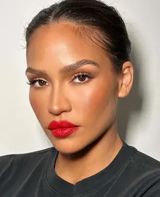 model wears natural eye makeup, mascara, and bright red matte lipstick