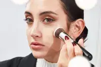 Person applying foundation to their face