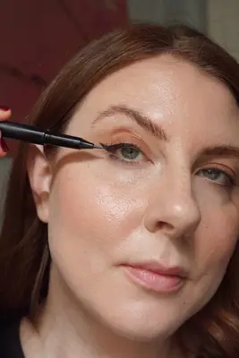 model applying black liquid liner to the top line of the lid 