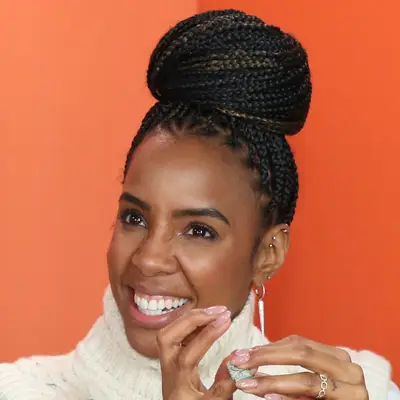 Kelly Rowland wears a minimalist makeup look and braided bun
