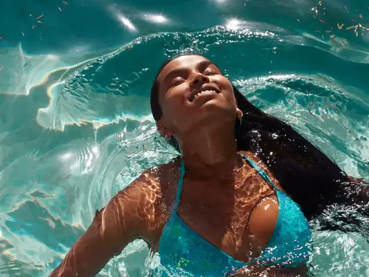 woman floating in pool smiling 