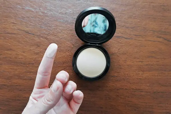 Collage of pressed powders we recommend on a grey background, including one by Fenty Beauty and one by Charlotte Tilbury