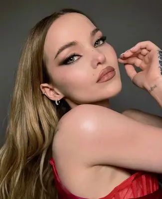 Dove Cameron wears winged smoky eyeshadow look paired with matte nude lipstick