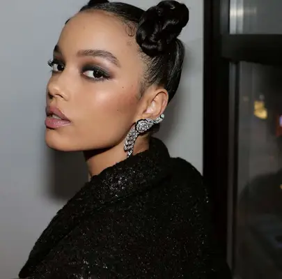 model wears smoky eye with a bold brow and glossy lips