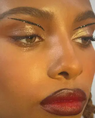 model is wearing black liner accents above the lids and deep red lipstick