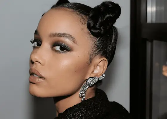 model wears smoky eye with a bold brow and glossy lips