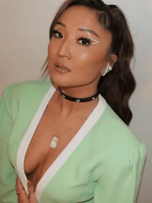 Ashley Park wears 60s inspired white eyeliner in an abstract wing shape