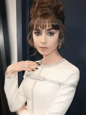 Lily Collins wears a 60s inspired makeup look with black cat eye and soft complexion