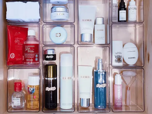 drawer of clear containers full of skincare and makeup