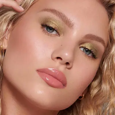 Close up of a blue-eyed model wearing golden eyeshadow