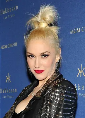 Gwen Stefani with a high messy topknot and red lipstick