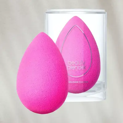 Beauty blender sponge and container on textured background