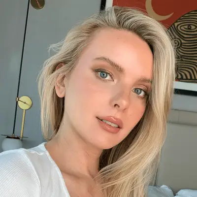 Woman with long blonde hair and natural glowy makeup