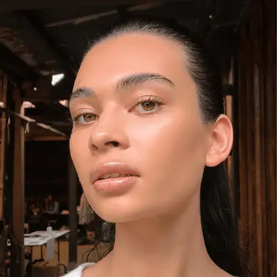 Model with natural nude makeup look and a slicked back ponytail