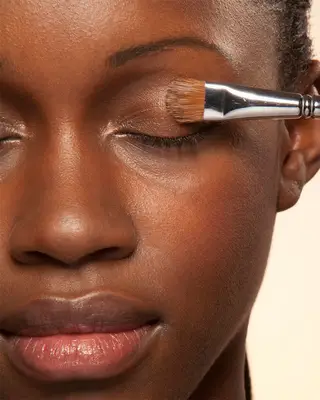 closeup of makeup brush on woman