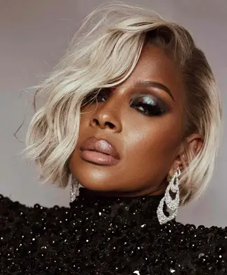Mary J. Blige wears a green metallic eyeshadow and light nude lipstick 