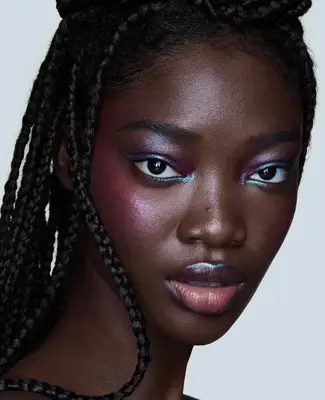 Model is wearing an iridescent blue and pink shadoe look with iridescent pink blush and sheer lips