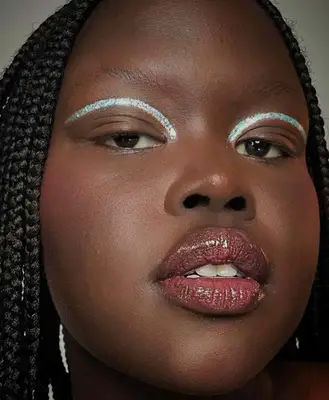 Model is wearing holographic glitter liner applied in the crease only 