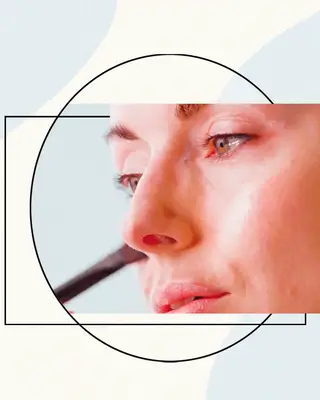 Woman Having Makeup Applied to Her Cheeks on a Designed Background